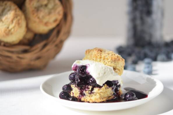 Blueberry shortcake with blueberries and biscuits in the background