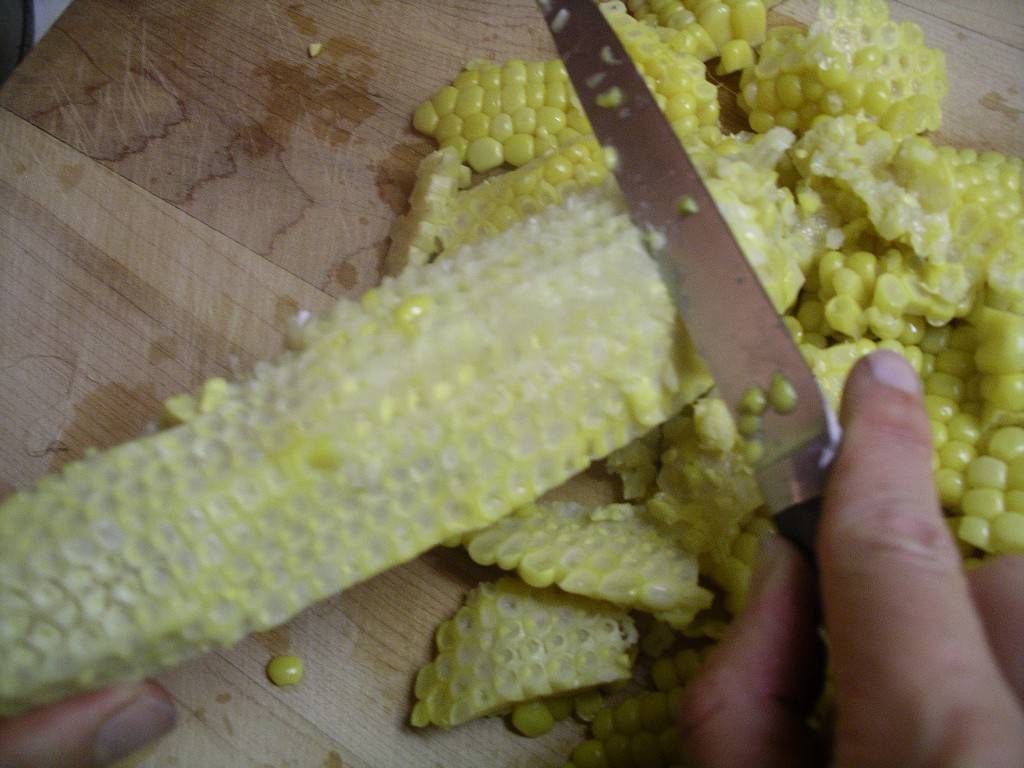 using the back of the knife to push out the corny goodness