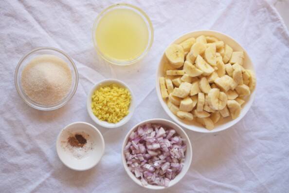 prepared ingredients for banana chutney arranged in white bowls