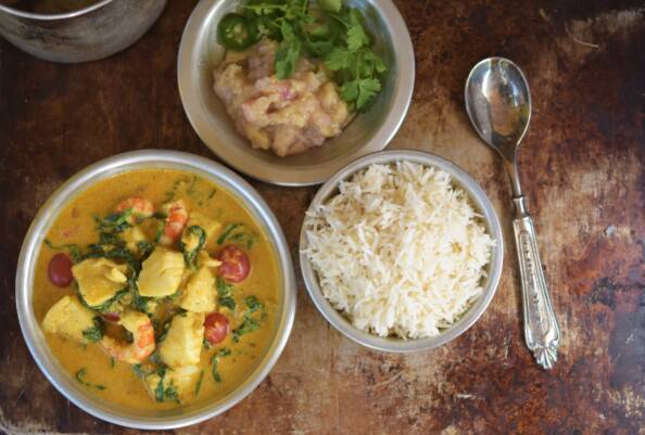 seafood curry, rice, chutney in silver bowls