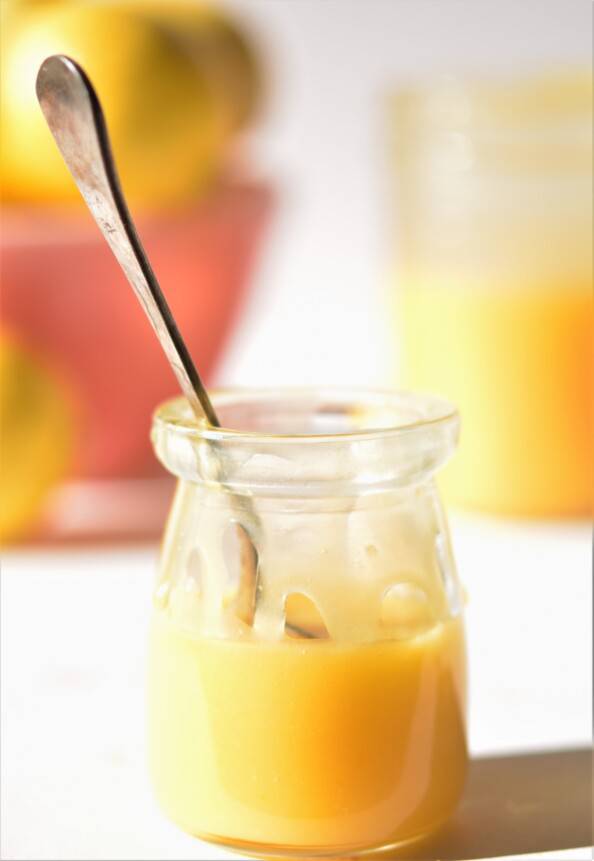 small jar of lemon curs with lemons in the background