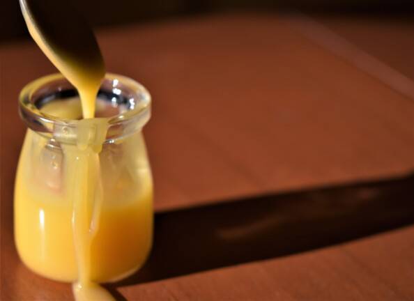 a small jar of lemon curd with a drizzle