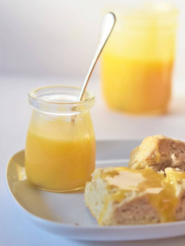 Two jars of lemon curd with a bsicuit