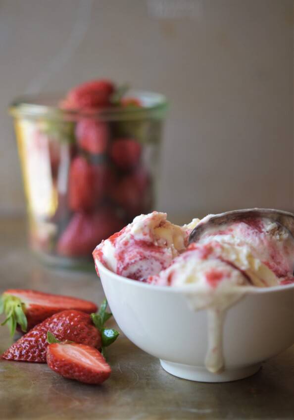 strawberry cheesecake ice cream with drip and berries