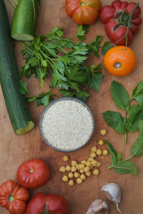 overhead shot of tabbouleh ingredients on a wooden cutting board