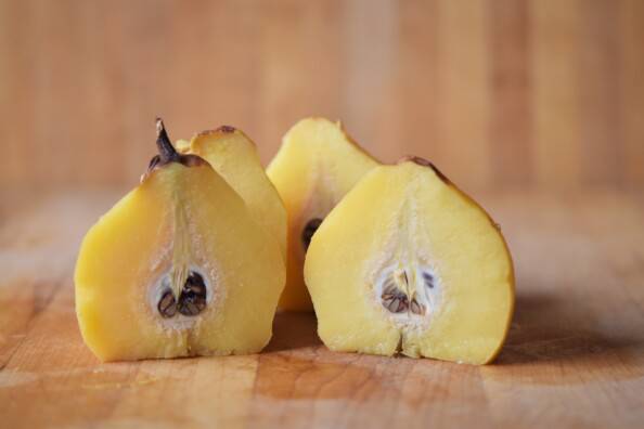 Quince cut in half through the core, displayed upright